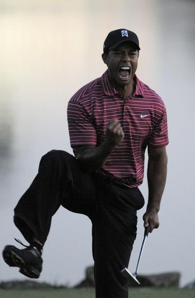 Tiger Woods celebrates after sinking the winning putt.  (Associated Press / The Spokesman-Review)