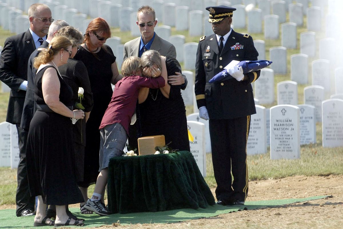 Heidy Baker is comforted by her grandson, Vernon Pawlik, at the burial of Vernon Baker on Friday, Sept. 24, 2010, at Arlington National Cemetery. Major General Reuben Jones holds the flag to the right and Baker