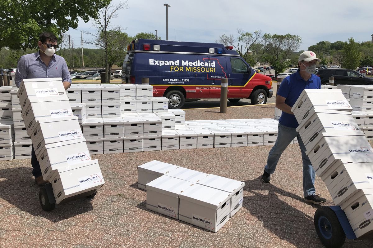 FILE - In this May 1, 2020, file photo, campaign workers David Woodruff, left, and Jason White, right, deliver boxes of the Healthcare for Missouri campaign initiative petitions signatures to the Missouri secretary of state