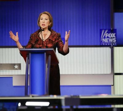 Republican presidential candidate businesswoman Carly Fiorina answers a question as former Arkansas Gov. Mike Huckabee, right, listens during a Republican presidential primary debate, in Des Moines, Iowa, tonight. (AP Photo/Charlie Neibergall) 