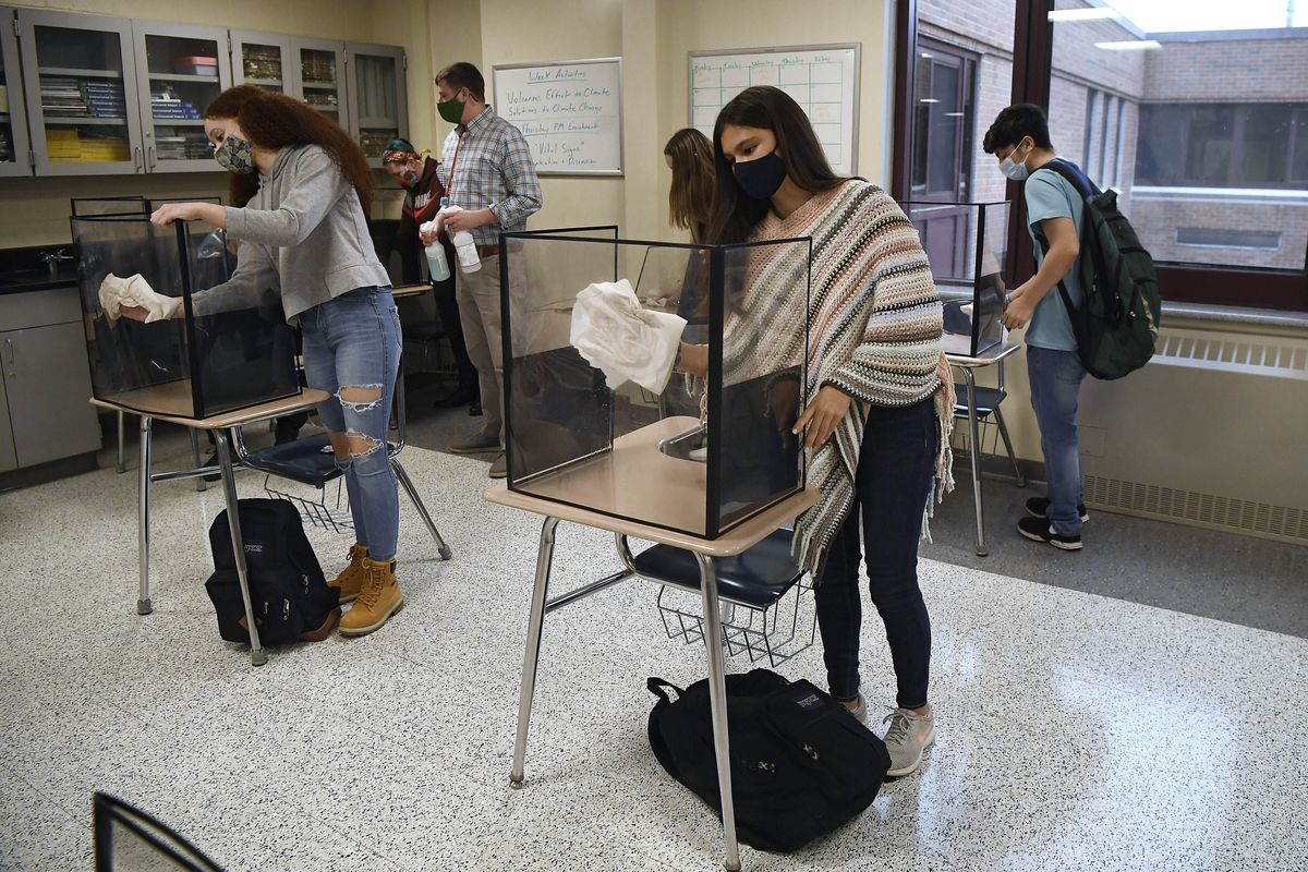 Students in teacher Christopher Duggan’s science class clean their work areas at the end of class on March 18 at Windsor Locks High School in Windsor Locks, Conn.  (Jessica Hill)