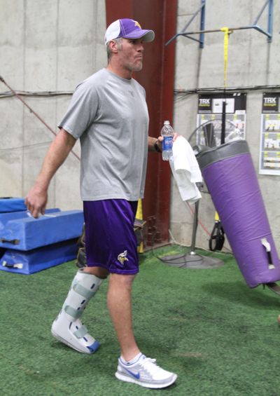Vikings QB Brett Favre, wearing a cast on his left leg, walks away after talking to media.  (Associated Press)