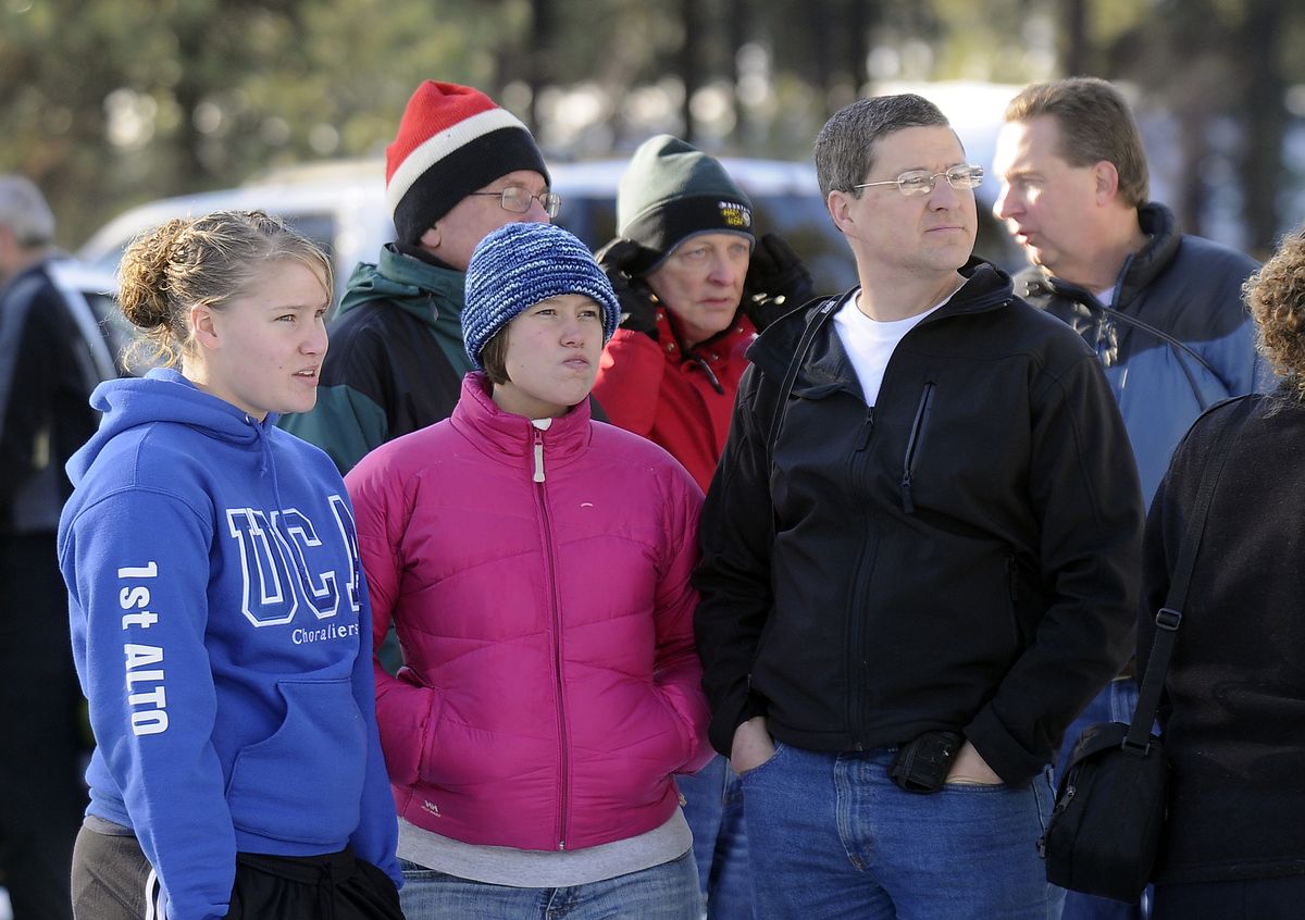 Onlookers watch the headquarters of the Seventh-day Adventist Church burn as an early-morning fire sweeps through the bookstore and main entrance of the building Sunday. (Dan Pelle / The Spokesman-Review)