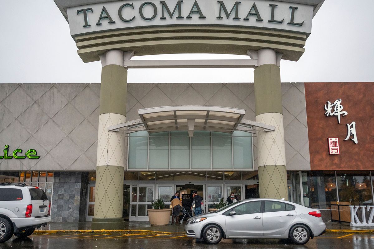 People walk into the north entrance of the Tacoma Mall, Saturday, Nov. 27, 2021, in Tacoma, Wash. A day earlier, multiple shots were fired inside the mall. One person was injured in the shooting.  (Pete Caster)