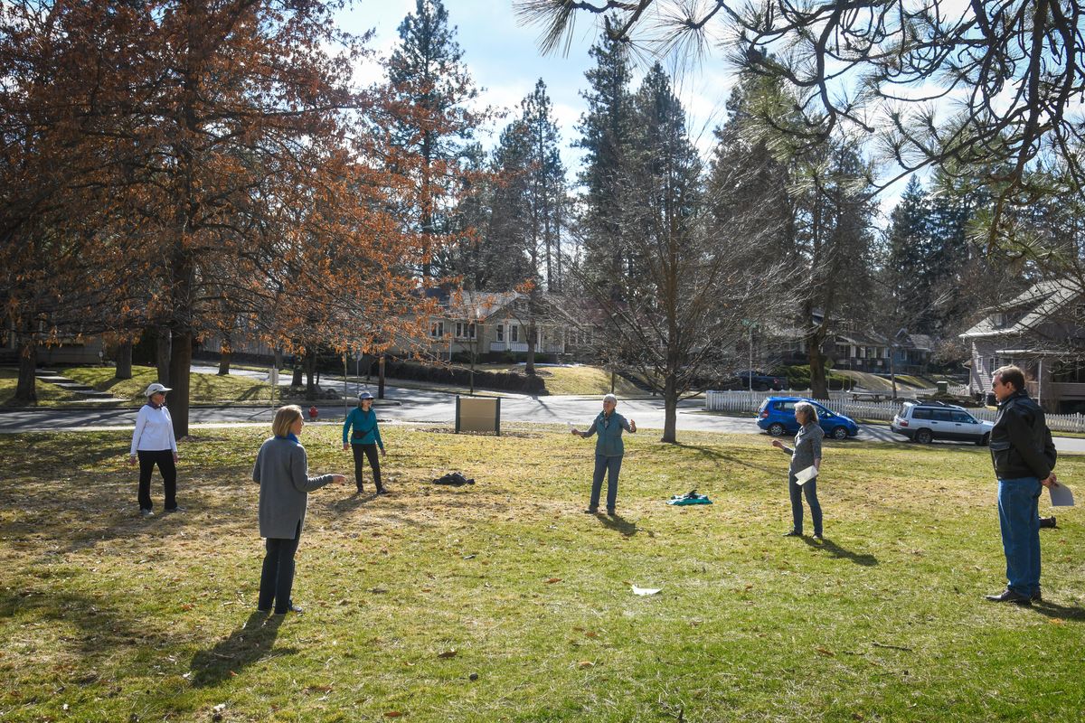 Keeping their distance apart because of COVID-19 concerns, Mary Beham, left, Robin Marks, Stephanie Schuler, Eileen Martin and Clint Hill gather in Upper Manito Park for a sing-along, Friday, March 20, 2020, in Spokane. (Dan Pelle / The Spokesman-Review)