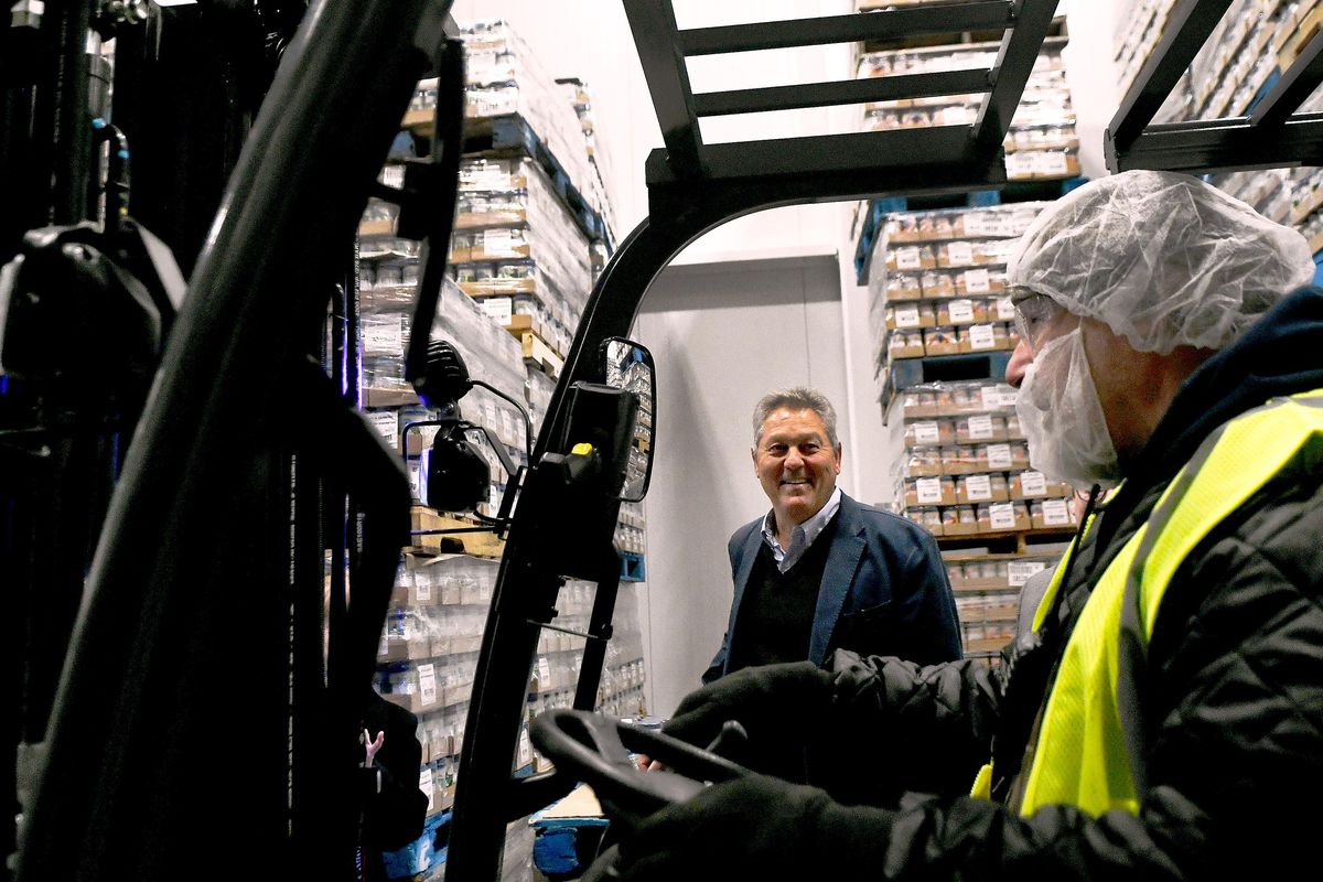 Litehouse Inc. President and CEO Jim Frank, center, smiles at Scooter Reichart after he drove a forklift through  a ribbon, cutting it during the celebration of the expansion of the company’s facility in Sandpoint on Wednesday, Jan. 31, 2018. (Kathy Plonka / The Spokesman-Review)