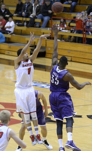 Eastern Washington University's Tyler Harvey arcs a trey over the outstretched arms of  Weber State defender Kyndahl Hill, part of the Eags second-half comeback, Thursday, Jan. 1, 2015 at EWU's Reese Court.  The Eagles battled back to beat the Wildcats 84-78. (Jesse Tinsley / The Spokesman-Review)