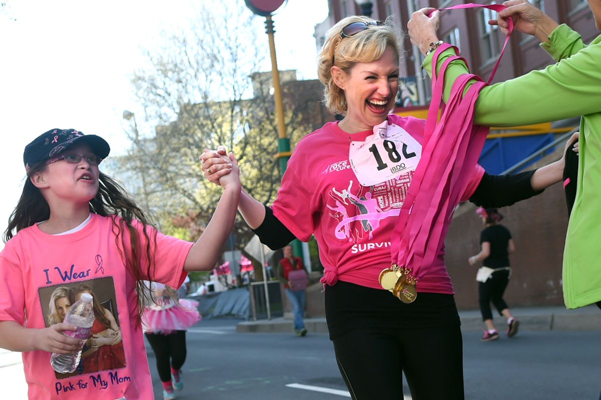 Breast cancer survivor Valerie Stichweh crosses the finish line with her daughter Faith, 11, during the Susan G. Komen Race for the Cure in Spokane on Sunday, April 17, 2016. (Kathy Plonka)