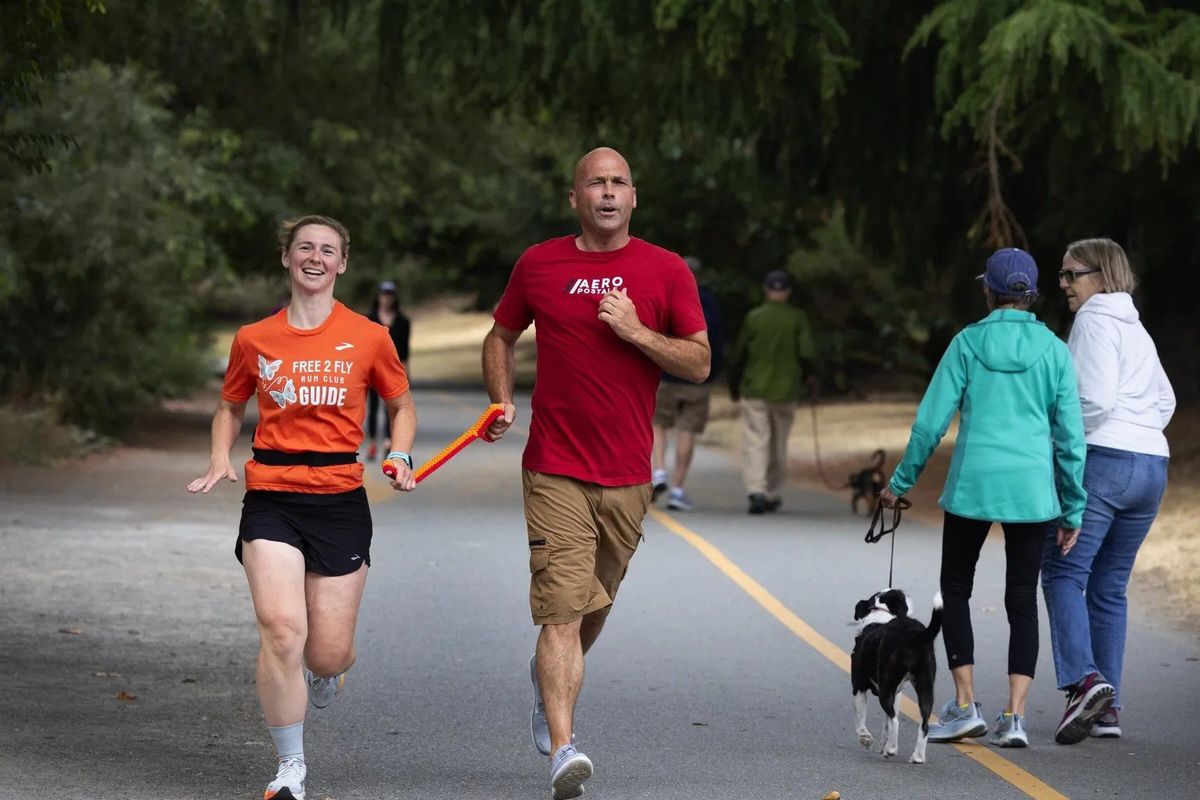 Sighted guide Mikayla Monroe is paired with visually impaired athlete Nick Angell, who is training for a half-marathon, during a meetup of the group Free 2 Fly, at Green Lake, Wash., on Aug. 3. (Ken Lambert/Seattle Times)