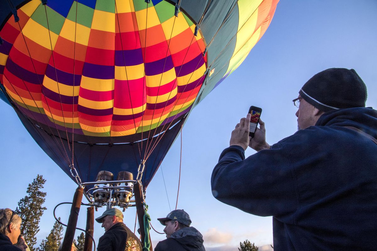 Mike Ellis photographs the early-morning Valleyfest hot air balloon launch on Sept. 24, 2016, at Centerplace in Spokane Valley. (Dan Pelle / The Spokesman-Review)