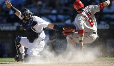 Maicer Izturis of the Angels slides around the tag of Seattle's Kenji Johjima. Associated Press
 (Associated Press / The Spokesman-Review)