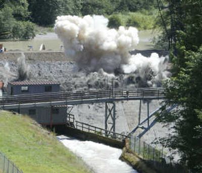 
Associated Press Dust and debris fly as explosives are set off on the Marmot Dam, visible behind bridge, on the Sandy River July 24, near Sandy, Ore., in the first step toward its complete removal. Removal of the 47-foot-tall dam will make the Sandy River a free-flowing river from Mount Hood glaciers to its mouth at the Columbia River for the first time in 95 years.
 (Associated Press / The Spokesman-Review)