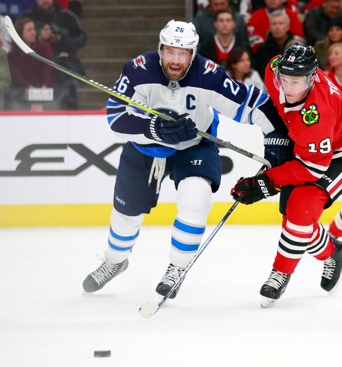 In this Jan. 12, 2018, file photo, Winnipeg Jets right wing Blake Wheeler (26) and Chicago Blackhawks center Jonathan Toews (19) vie for the puck during the first period of an NHL hockey game in Chicago. Wheeler is one of about a dozen players in the NHL MVP race. (Jeff Haynes / Associated Press)