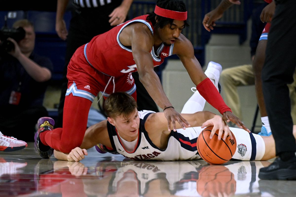 Gonzaga forward Ben Gregg (33) and Loyola Marymount guard Dominick Harris (55) chase a loose ball during the first half of a NCAA college basketball game, Tuesday, Jan. 30, 2024, in the McCarthey Athletic Center.  (COLIN MULVANY)
