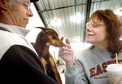 
Karen Rasler, right, of Spokane, greets J.J., a chocolate miniature pinscher, and Allan Thornton, also from Spokane. 
 (Joe Barrentine / The Spokesman-Review)