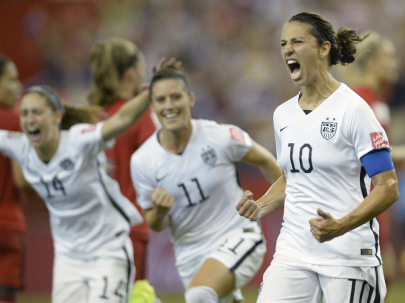 United States' Carli Lloyd, right, celebrates with teammates Ali Krieger, center, and Morgan Brian after scoring on a penalty kick against Germany in the second half. (Associated Press)
