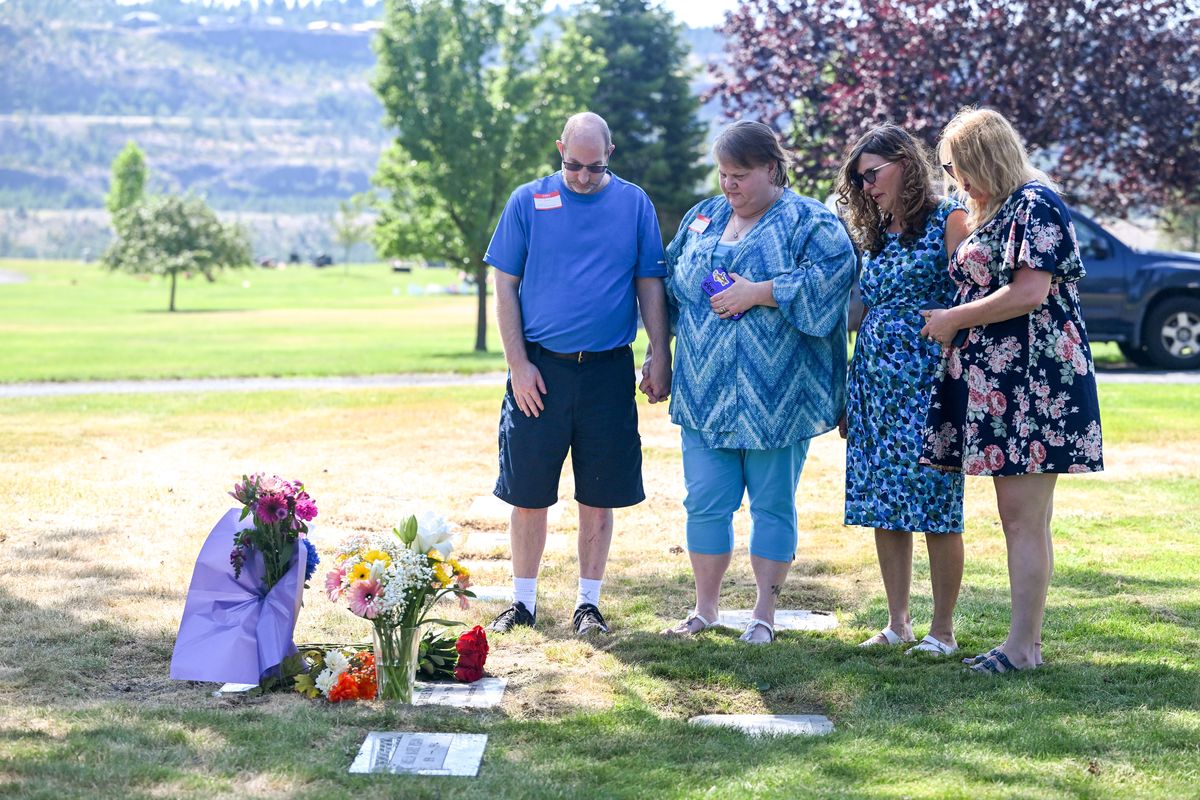 Tim Rau, JulieAnn Rau, Pauline Franklin and Sherry Franklin pause Friday at the grave of Ruth Belle Waymire, a cold case homicide victim found 40 years ago in Spokane. For most of the years she was missing, she was unidentified.  (Jesse Tinsley/THE SPOKESMAN-REVIEW)