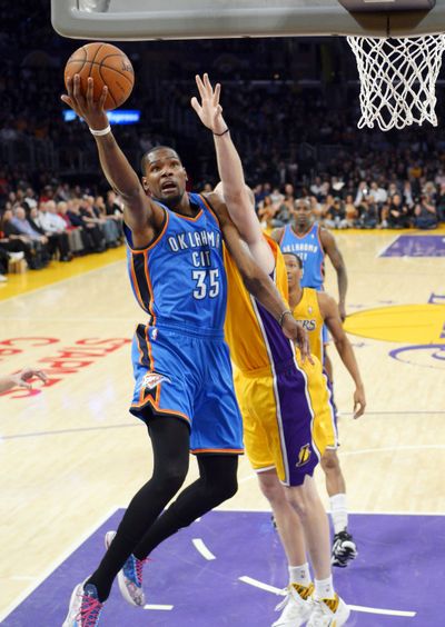 Thunder forward Kevin Durant, left, puts up a shot as Lakers center Chris Kaman defends during OKC’s 107-103 win over L.A. (Associated Press)