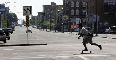 A skateboarder heads north across Main Avenue on Thursday. The left lane of the block beyond him will be closed for a parking lot expansion planned by the Public Facilities District. (Dan Pelle / The Spokesman-Review)