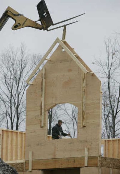 
Workers build a house in Clarence, N.Y. The slumping housing market was one factor in the government revising its economic forecast on Thursday.Associated Press
 (Associated Press / The Spokesman-Review)
