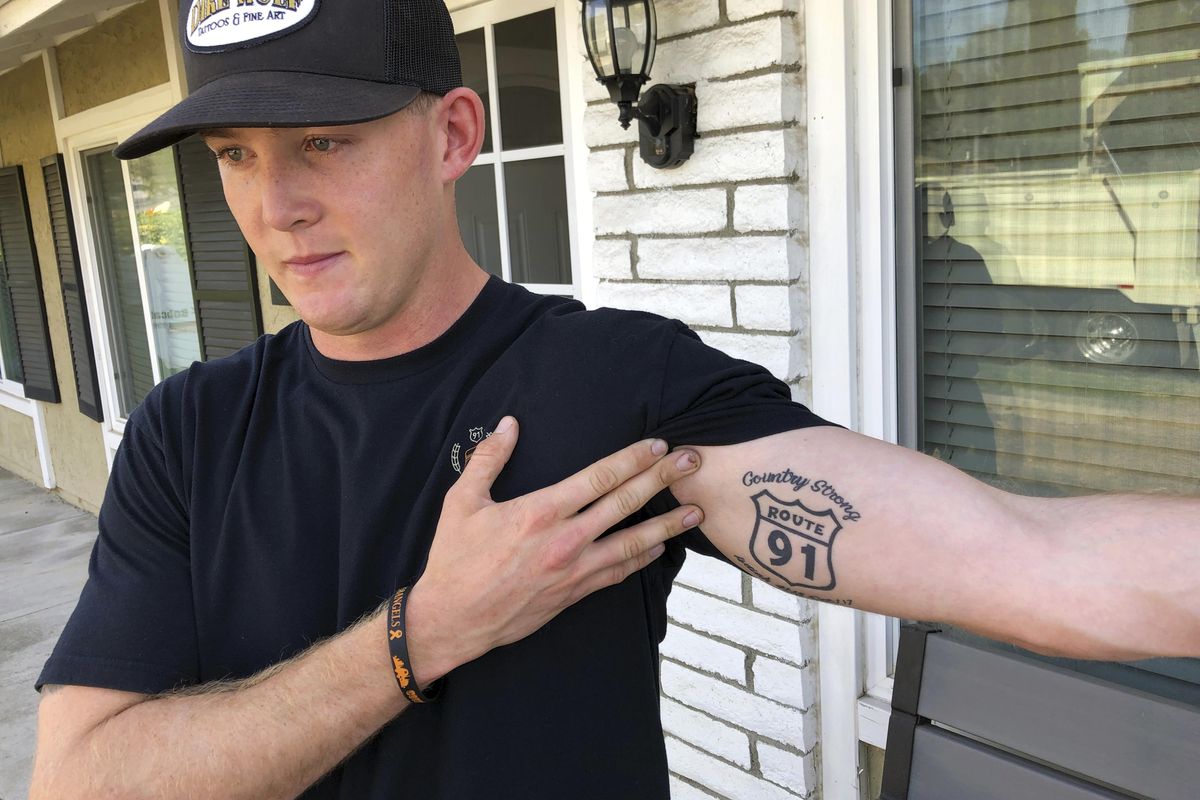 Brendan Kelly speaks with reporters outside his home, as he shows his Route 91 tattoo, Thursday, Nov. 8, 2018, in Thousand Oaks, Calif. Kelly, a Marine who was at Borderline Bar and Grill on Wednesday night, helped people get out after a gunman opened fire at the establishment. Kelly also survived the Las Vegas Route 91 Harvest Festival shooting in 2017. (Ryan Pearson / AP)