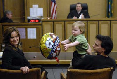 
Jill and Jim Bruce share a moment with  their new son, Josh,  as Pro Tem Commissioner Richard Kayne, background, looks on Friday  at the Spokane County Courthouse. 
 (Dan Pelle / The Spokesman-Review)