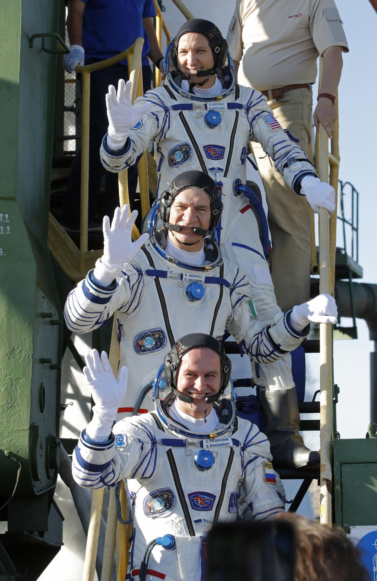 U.S. astronaut Randy Bresnik, top, Russian cosmonaut Sergey Ryazanskiy, bottom, and Italian astronaut Paolo Nespoli, crew members of the mission to the International Space Station, ISS, wave near the rocket prior the launch of Soyuz-FG rocket at the Russian leased Baikonur cosmodrome, Kazakhstan, Friday, July 28, 2017. (Dmitri Lovetsky / Associated Press)