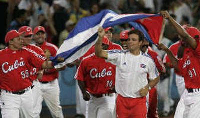 
The Cuban baseball team carries their flag around the field after defeating Australia 6-2 in the gold medal game.
 (Associated Press / The Spokesman-Review)