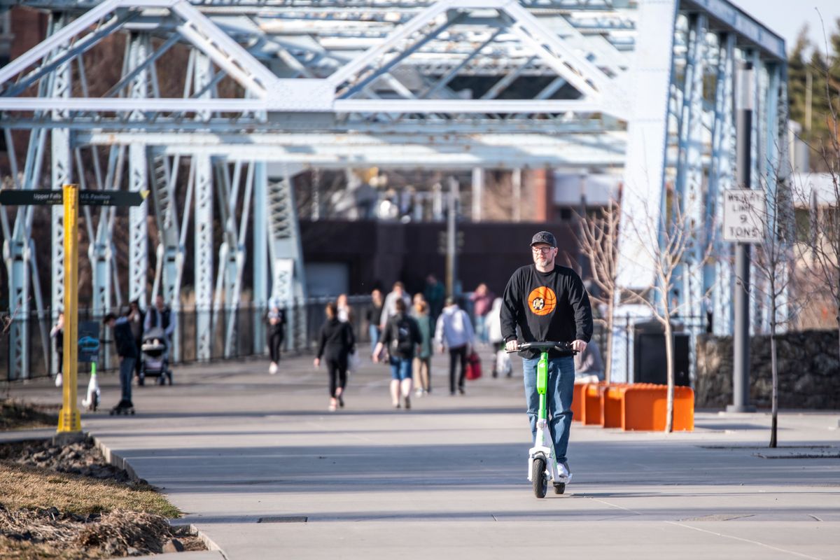 Adam Smith rides around Riverfront Park on a Lime scooter on March 19.  (Jesse Tinsley/The Spokesman-Review)