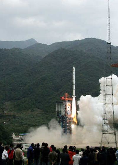 
A crowd watches China's first moon orbiter  lift off from the Xichang Satellite Launch Center in  Sichuan province Wednesday. The probe  is the first step in a plan to land a man on the moon.Associated Press
 (Associated Press / The Spokesman-Review)