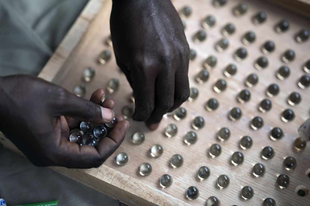 An electoral worker uses a counting board to tally marbles from a polling station during Gambia's presidential elections in Serrekunda, Gambia, Saturday, Dec. 4, 2021. Gambians vote in a historic election, one that for the first time will not have former dictator Yahya Jammeh appearing on the ballot.  (Leo Correa)
