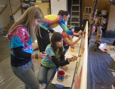 
In preparation for the homecoming bench assembly, University High School seniors, front to back, Brittany Spurbeck, 17; Tara Stauffer; 17; and Laura Leach, 17, paint the class bench in Leach's garage.  
 (Colin Mulvany / The Spokesman-Review)