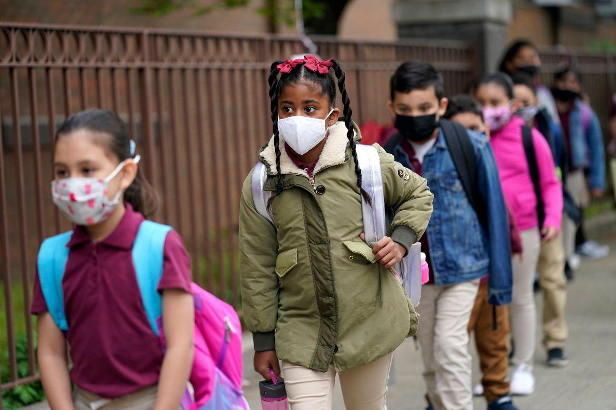 FILE - Students line up to enter Christa McAuliffe School in Jersey City, N.J., April 29, 2021. New Jersey Gov. Phil Murphy will end a statewide mask mandate to protect against COVID-19 in schools and child care centers, his office said Monday, Feb 7, 2022.  (Seth Wenig)