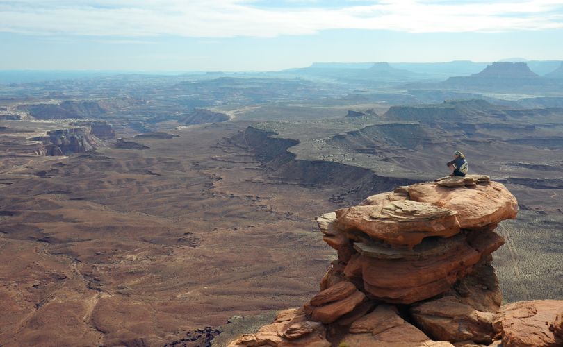 ABOVE: Mary Jantsch, a Gonzaga University student, perches on a rock outcropping overlooking Canyonlands National Park near Moab, Utah, during spring break 2012.