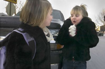 
Six-year-old Ashlynn Thielen, left, and her 8-year-old sister, Elizabeth, wait with their father for their school bus Friday in Spokane Valley.  The temperature was hovering near zero. The girls are students at Greenacres Elementary School where, despite the cold weather, no classes were canceled. 
 (Christopher Anderson / The Spokesman-Review)