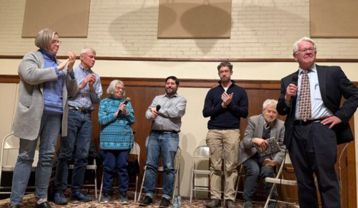 Heath Druzin (center) is applauded by panelists at a Dec. 17 meeting of Moscow residents concerned about the growing influence of Christ Church in the city.  (Tracy Simmons/Faith and Values)