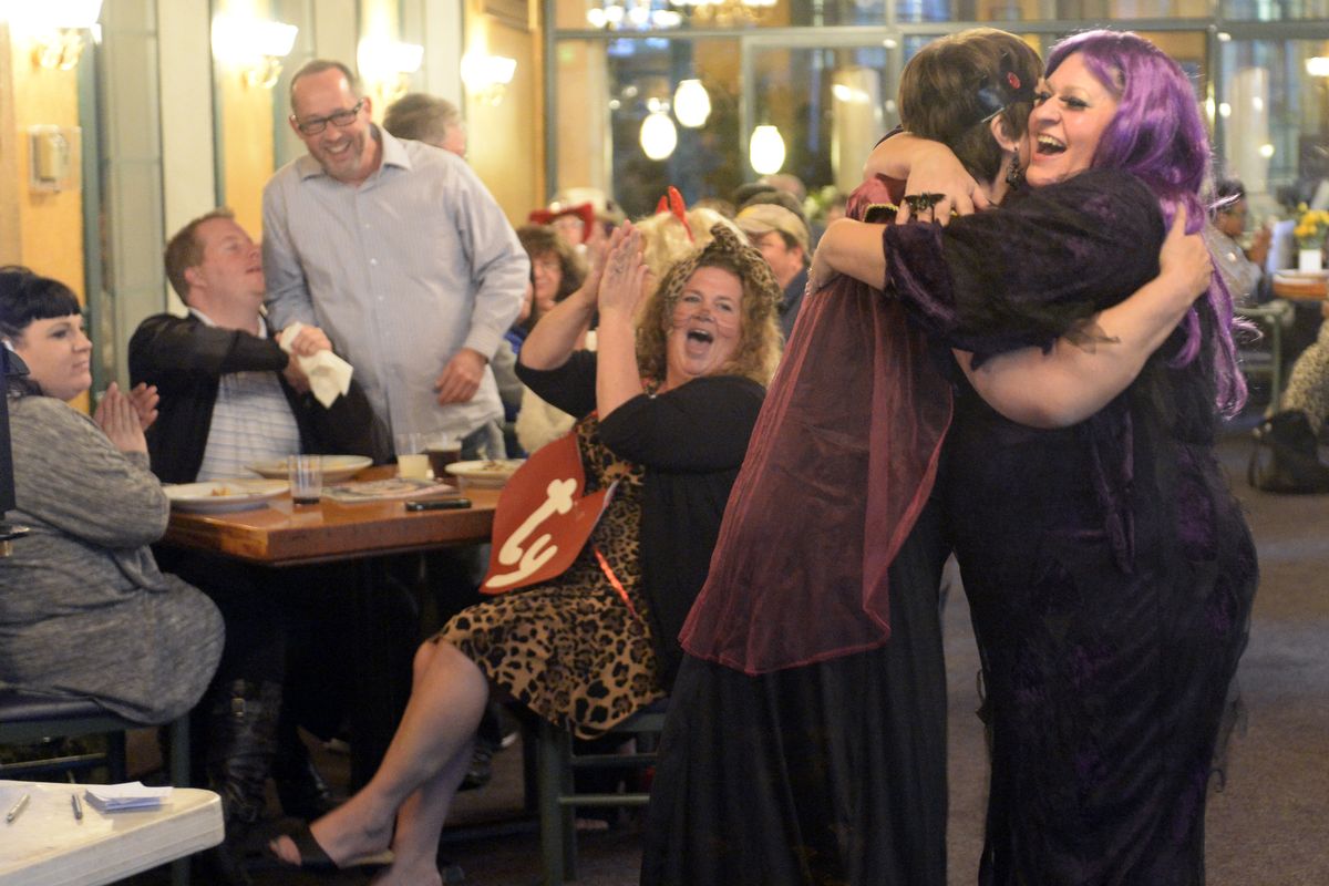 Northwest Dinner Among Friends organizer Cristina Antles, right, hugs an attendee after a successful karaoke performance at their Halloween-themed event on Oct. 17 at Bangkok Thai in Spokane. The group puts on monthly dinners, usually with games, karaoke or dancing. (Jesse Tinsley)