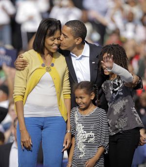 Democratic presidential candidate, Sen. Barack Obama, D-Ill., center, kisses his wife, Michelle, as they are joined by daughters Sasha and Malia, left, at a rally in Columbus, Ohio. (The Spokesman-Review)