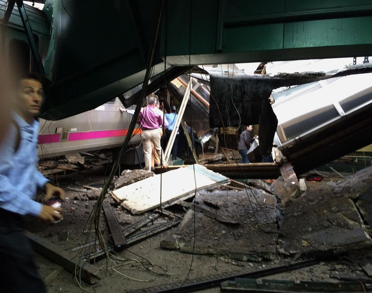 In a photo provided by William Sun, people examine the wreckage of a New Jersey Transit commuter train that crashed into the train station during the morning rush hour in Hoboken,, N.J., Thursday, Sept. 29, 2016. The crash caused an unknown number of injuries and witnesses reported seeing one woman trapped under concrete and many people bleeding. (William Sun / Associated Press)