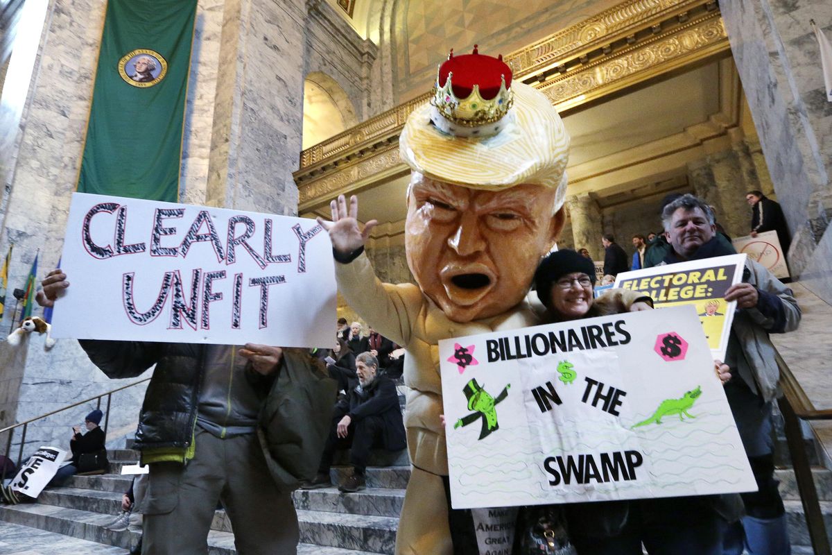 Jo Walter, of Bremerton, wears a large Donald Trump head mock-up as she protests Electoral College voting Monday, Dec. 19, 2016, in Olympia. (Elaine Thompson / Associated Press)