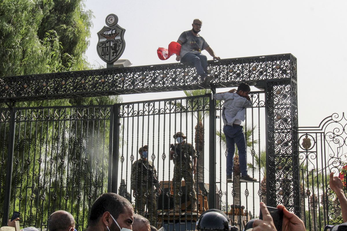 Tunisian soldiers guard the main entrance of the parliament as demonstrators gather outside the the gate in Tunis, Tunisia, Monday, July 26, 2021. Troops surrounded Tunisia