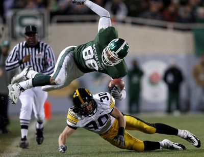Michigan State’s Brian Linthicum is upended by Iowa’s Kyle Spading during the second quarter Saturday.  (Associated Press / The Spokesman-Review)