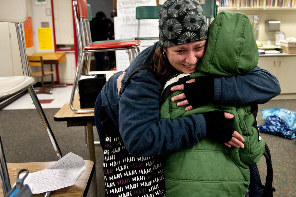 After watching news reports of the school shooting in Connecticut, Alicia Combo tightly hugs her son, Morgan Askins, at the close of the school day Friday at Garfield Elementary. (Dan Pelle)
