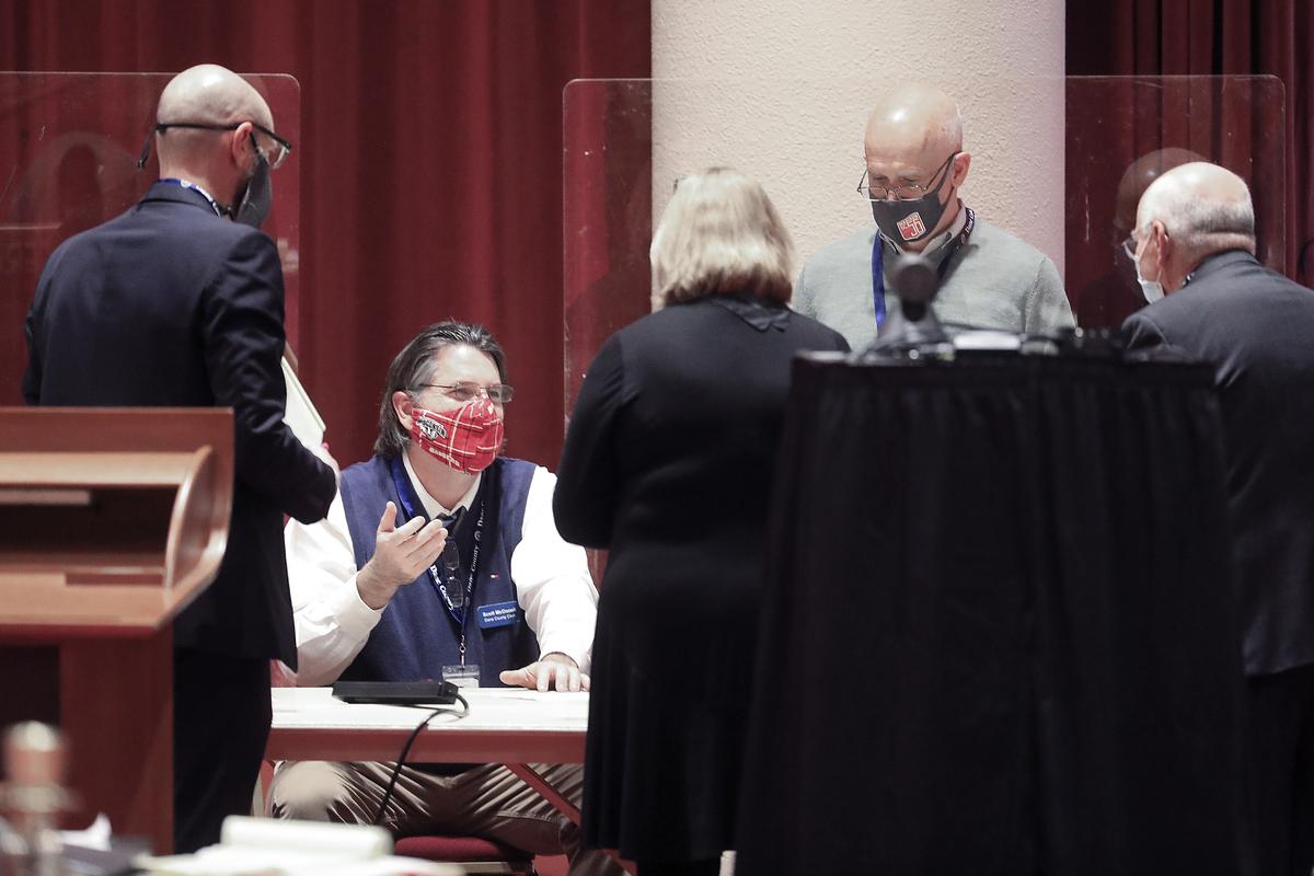 FILE - In this Nov. 20, 2020, file photo, Dane County Clerk Scott McDonell, seated, converses with election workers and legal representatives from the Joe Biden and Donald Trump presidential campaigns as a recount of the 2020 presidential election begins at the Monona Terrace convention center in Madison, Wis. President Trump filed a lawsuit Tuesday, Dec. 1, 2020, in Wisconsin, seeking to disqualify hundreds of thousands of ballots in a longshot attempt to overturn Democrat Joe Biden