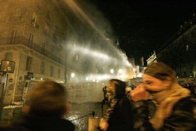 
Protesters run away from a water cannon behind riot shields during clashes near the Sorbonne University, following a student protest against the First Job Contract in Paris, France, on Saturday. 
 (Associated Press / The Spokesman-Review)