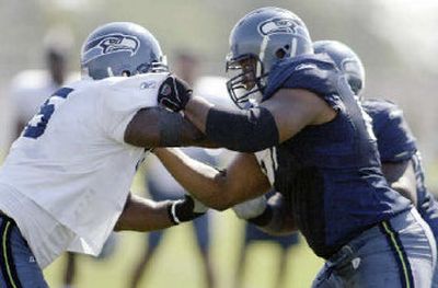 
Seattle Seahawks guard Rob Sims, right, blocks defensive tackle Russell Davis during training camp on Monday in Cheney. 
 (Associated Press / The Spokesman-Review)
