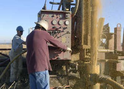 
Ron Sink, right, a driller for Enviromental West Exploration Inc., and Tim Smith  drill a monitoring well near the corner of Euclid and Wood Road near Deep Creek on Tuesday. 
 (Dan Pelle / The Spokesman-Review)