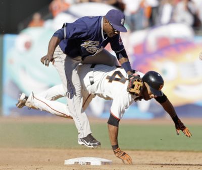 Padres shortstop Miguel Tejada, top, tumbles over Giants pinch runner Darren Ford. (Associated Press)