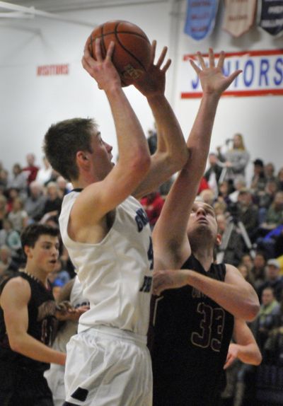 Gonzaga Prep’s Jacob Groh, left, scores over University’s Ben Kuiper. Groh totaled 21 points. (Jesse Tinsley)