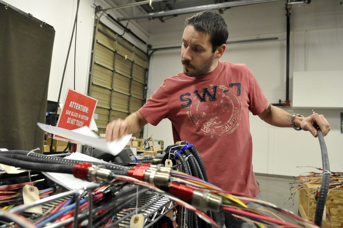 Darren McMIllin looks at forms that tell him the type of wire bundle to assemble on Feb. 3 at Hotstart, a manufacturer of engine heaters and preheaters. (Jesse Tinsley)